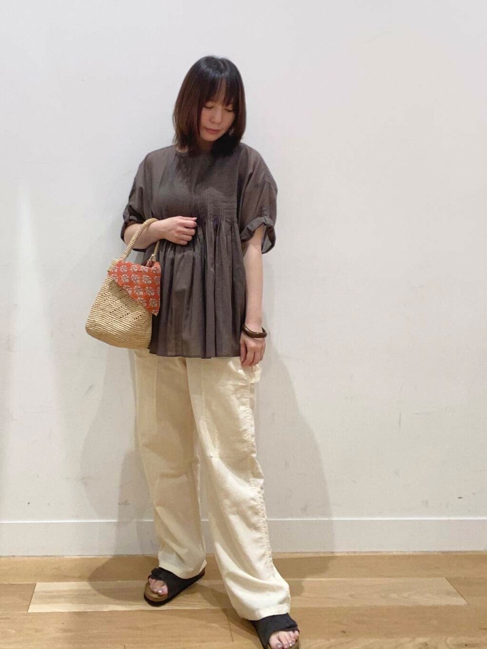 ベージュ系のタンクトップ、ホワイト系のその他パンツ、グリーン系のシャツ/ブラウスを着用したレディースの夏コーディネートの3枚目の写真