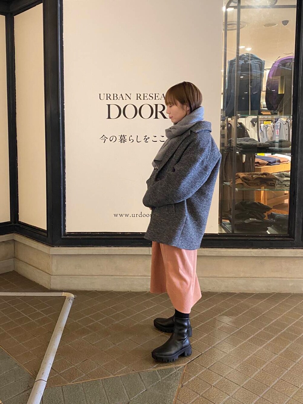 ブラック系のブーツ、グレー系のその他アウター、ピンク系のワンピースを着用したレディースの冬コーディネートの3枚目の写真