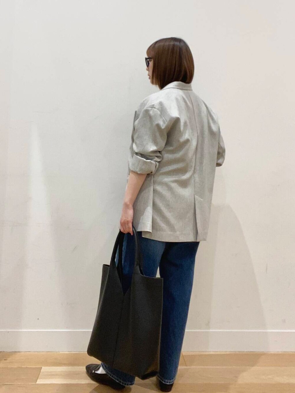 ブラック系のローファー、ブルー系のデニムパンツ、ブラック系のトートバッグを着用したレディースの春コーディネートの5枚目の写真