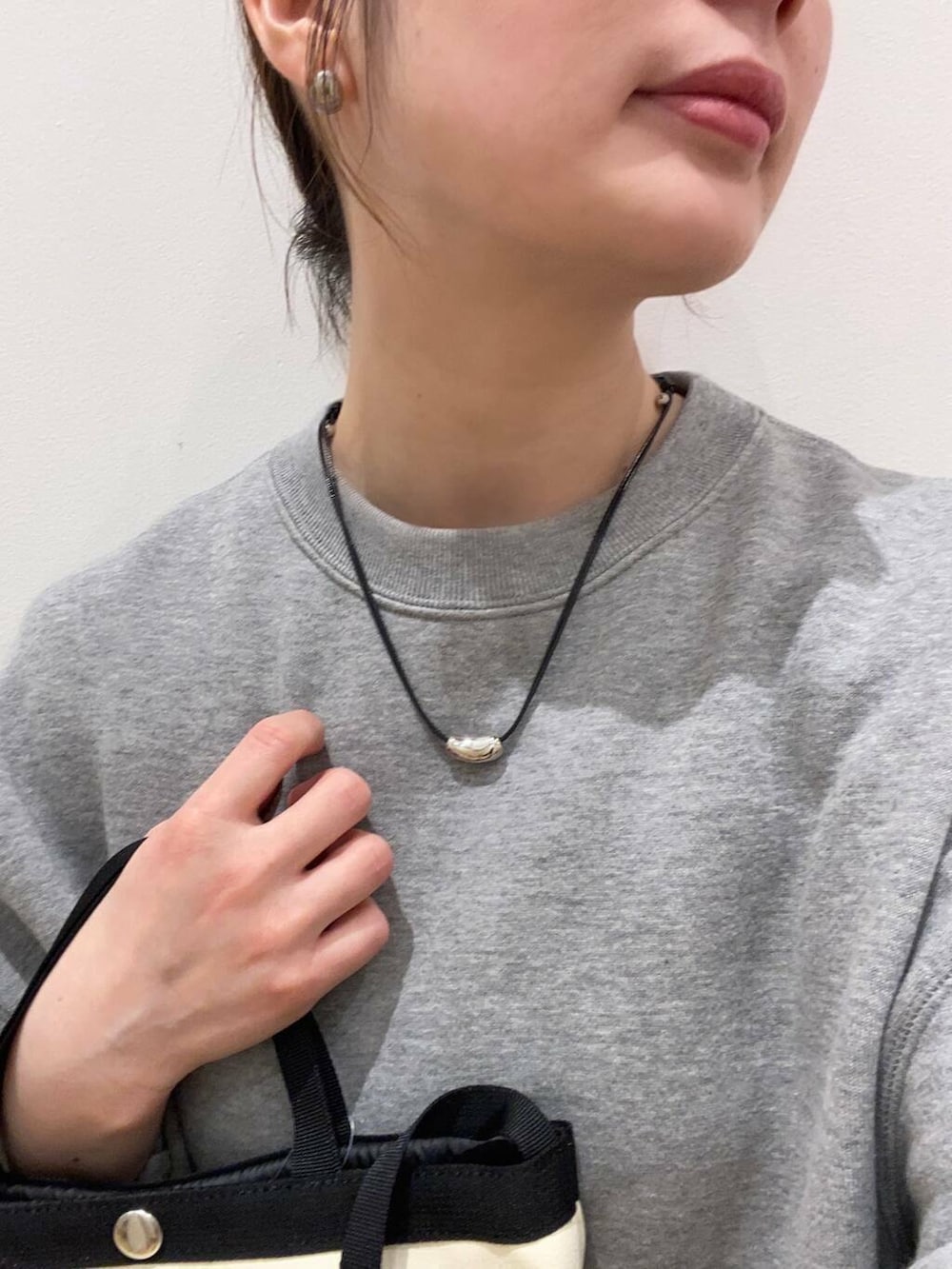 ブラック系のスカート、ベージュ系のスニーカー、グレー系のスウェットを着用したレディースの春コーディネートの6枚目の写真