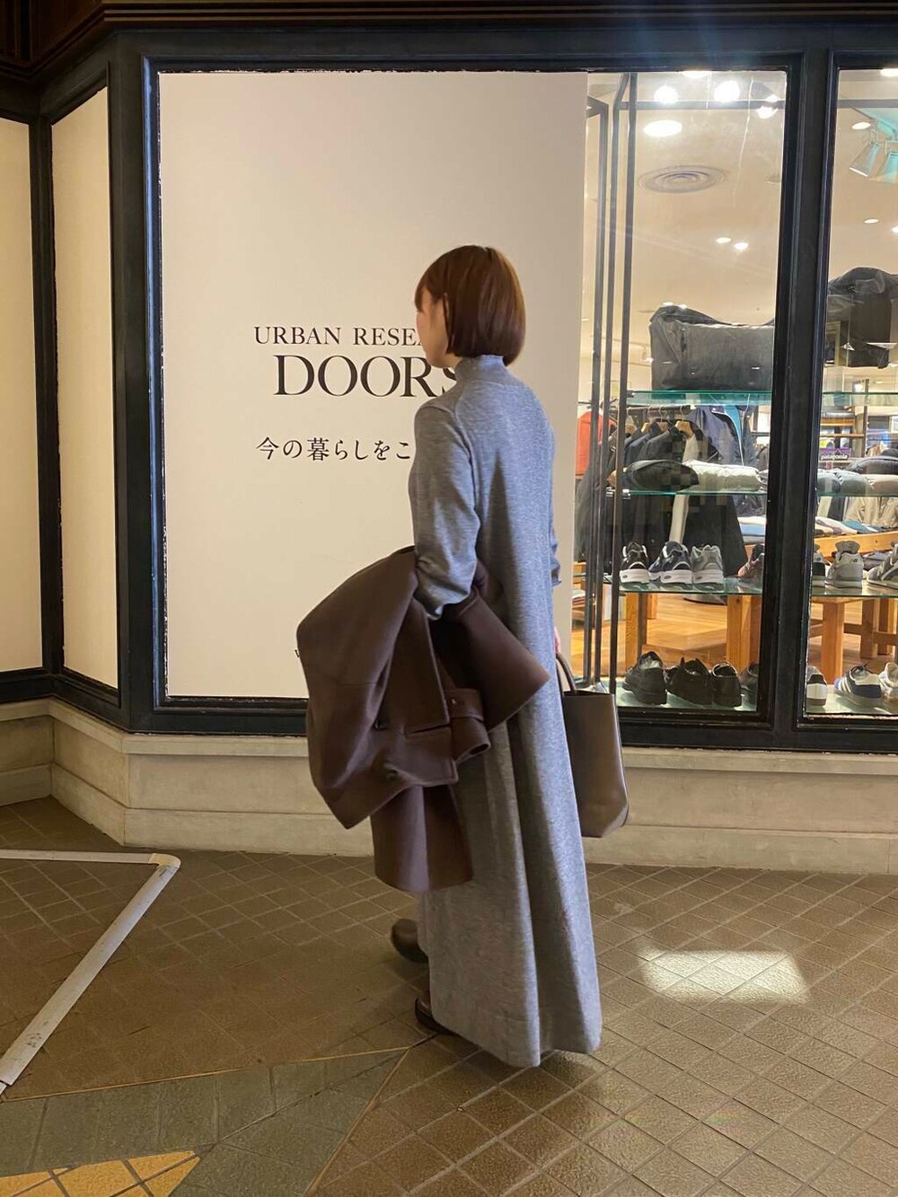 グレー系のトートバッグ、ブラウン系のブーツ、ブラウン系のその他アウターを着用したレディースの秋コーディネートの5枚目の写真