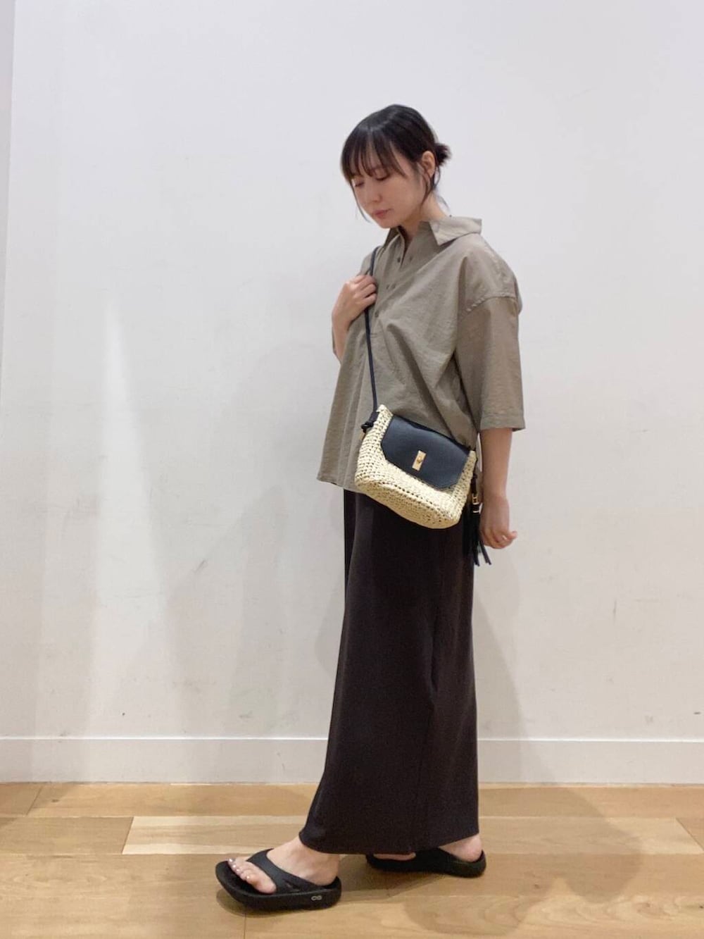 ベージュ系のショルダーバッグ、ブラック系のサンダル、ベージュ系のシャツ/ブラウスを着用したレディースの夏コーディネートの4枚目の写真