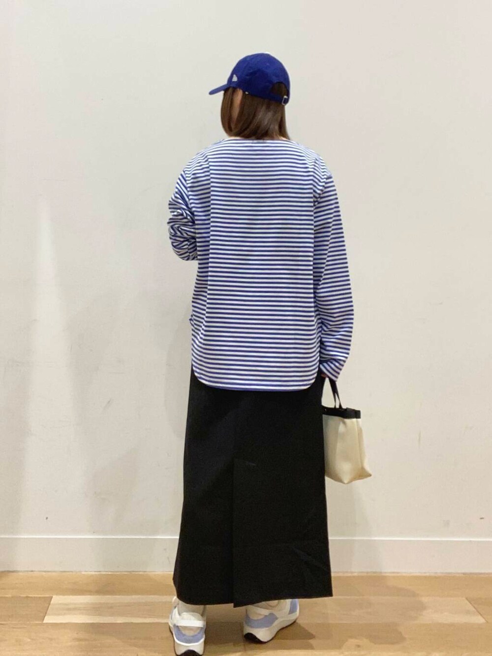 ブルー系のTシャツ/カットソー、ホワイト系のショルダーバッグ、ブルー系のスニーカーを着用したレディースの春コーディネートの4枚目の写真