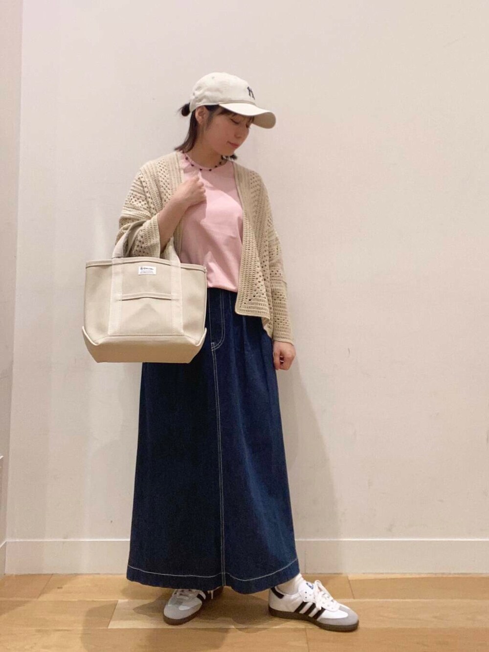ホワイト系のスニーカー、ピンク系のTシャツ/カットソー、ブルー系のスカートを着用したレディースの春コーディネートの2枚目の写真