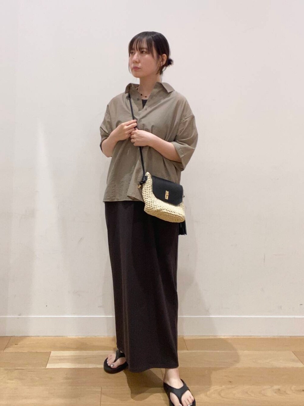ベージュ系のショルダーバッグ、ブラック系のサンダル、ベージュ系のシャツ/ブラウスを着用したレディースの夏コーディネートの5枚目の写真