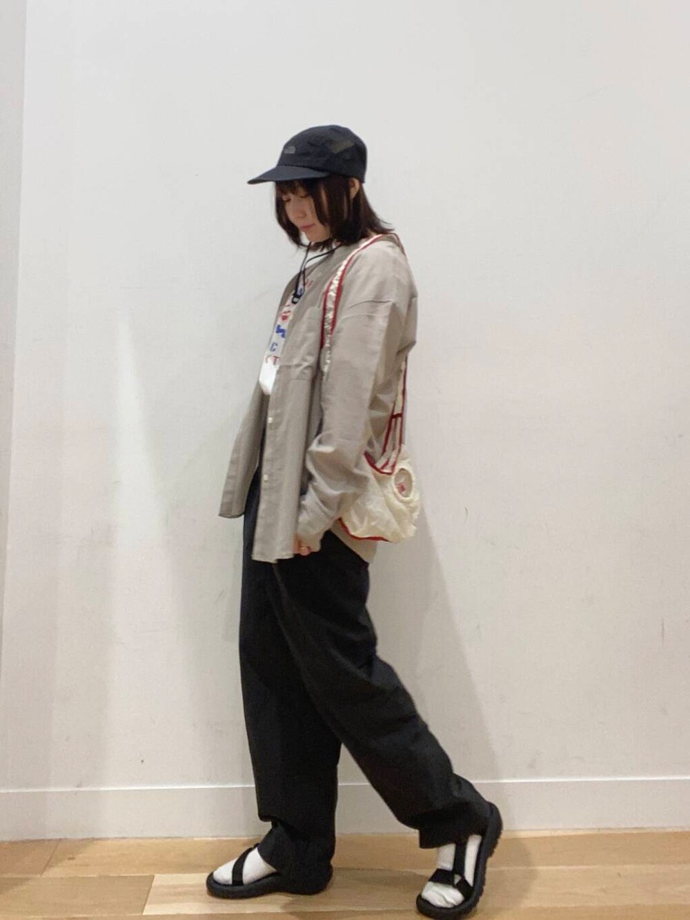 ホワイト系のTシャツ/カットソー、ベージュ系のシャツ/ブラウス、ブラック系のサンダルを着用したレディースの春コーディネートの3枚目の写真