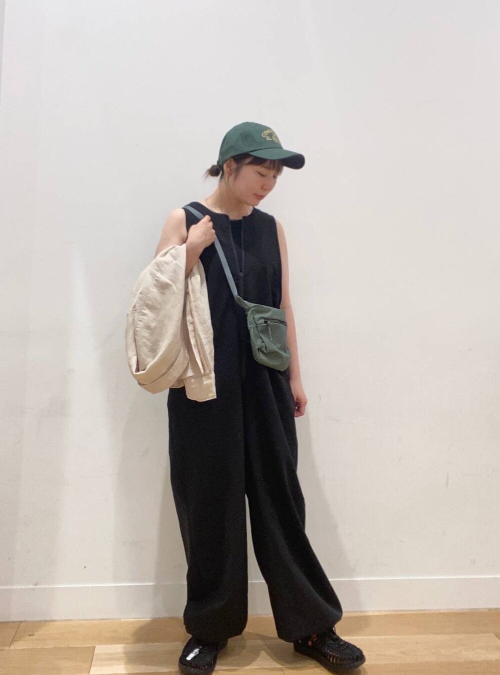 ブラック系のワンピース、ブラック系のタンクトップ、グリーン系のショルダーバッグを着用したレディースの夏コーディネートの4枚目の写真