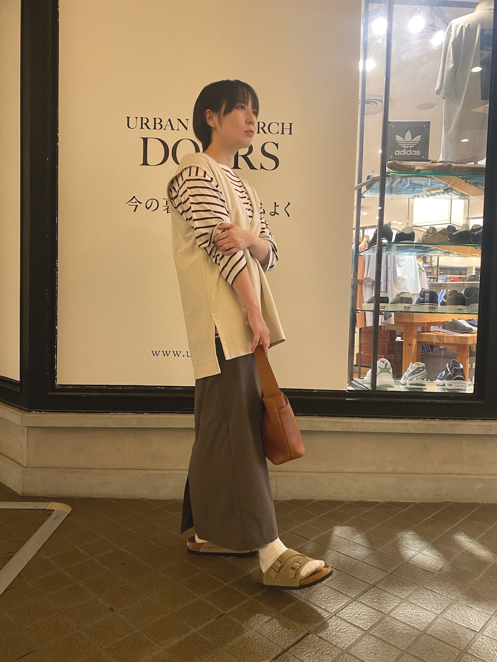 ホワイト系のベスト、レッド系のTシャツ/カットソー、イエロー系のショルダーバッグを着用したレディースの夏コーディネートの4枚目の写真