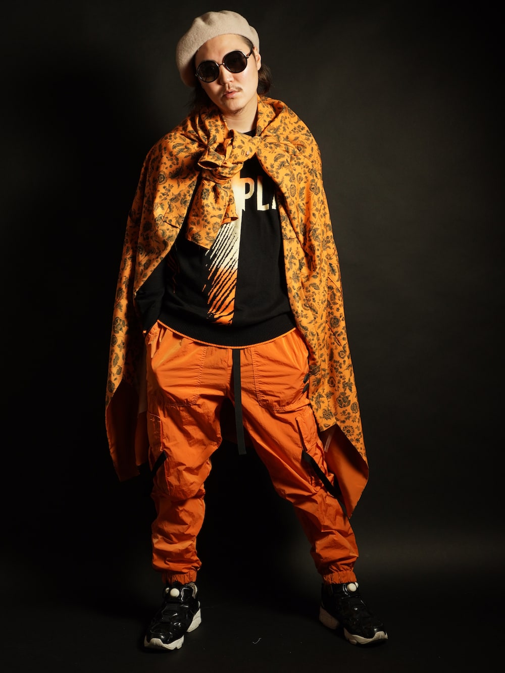 ブラウン系のボストンバッグ、オレンジ系のその他パンツ、ホワイト系のスニーカーを着用したメンズの冬コーディネートの3枚目の写真