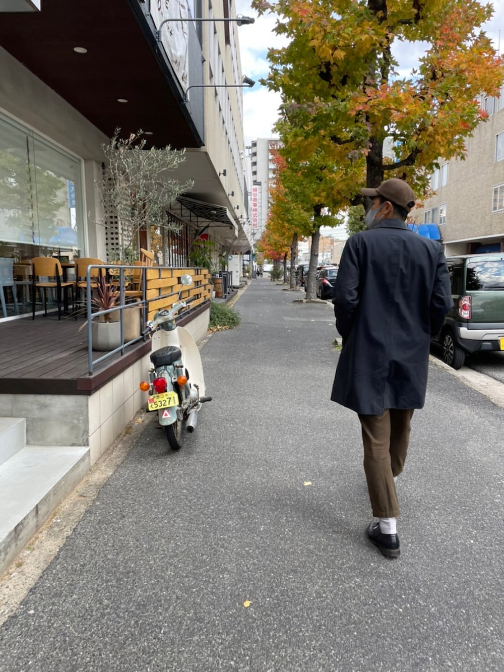 ブルー系のステンカラーコート、ブラック系のローファー、ベージュ系のスウェットを着用したメンズの秋コーディネートの2枚目の写真