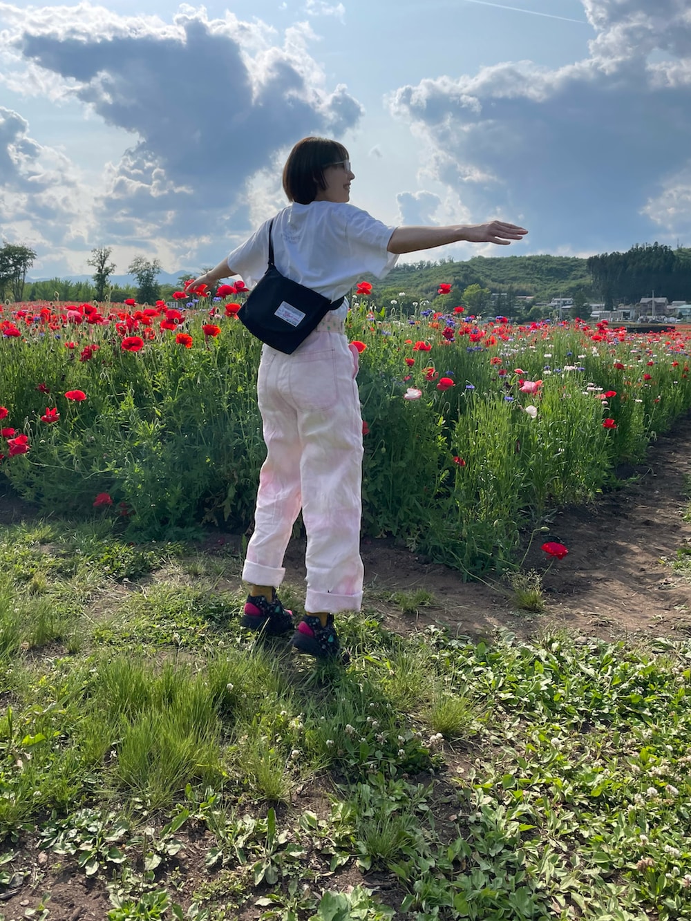 ホワイト系のTシャツ/カットソー、ピンク系のパンツ、ブラック系のサンダルを着用したレディースの春コーディネートの2枚目の写真