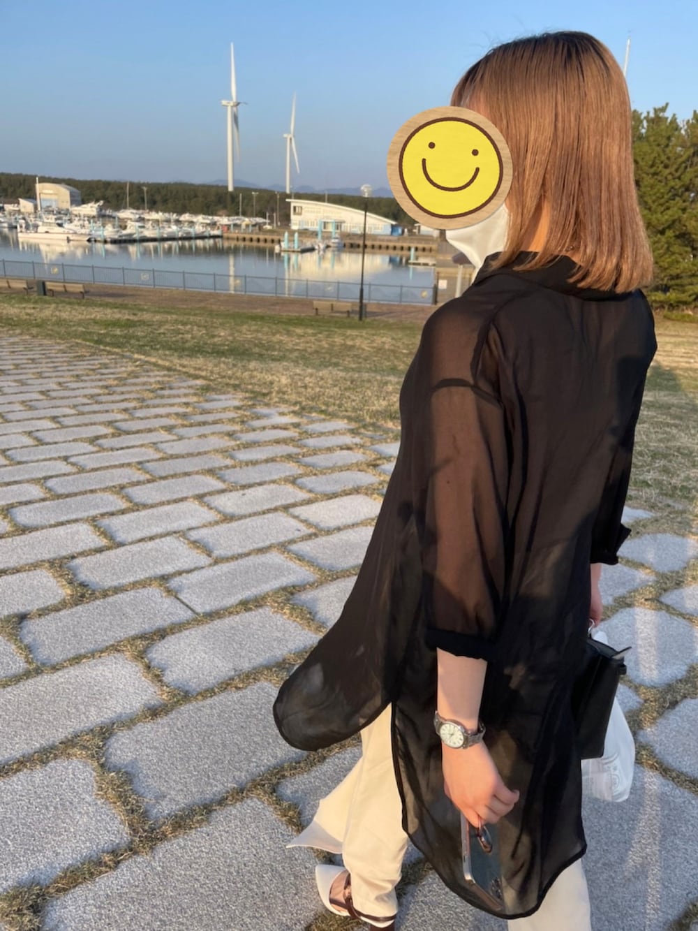 ベージュ系のスラックスを着用したレディースの春コーディネートの2枚目の写真