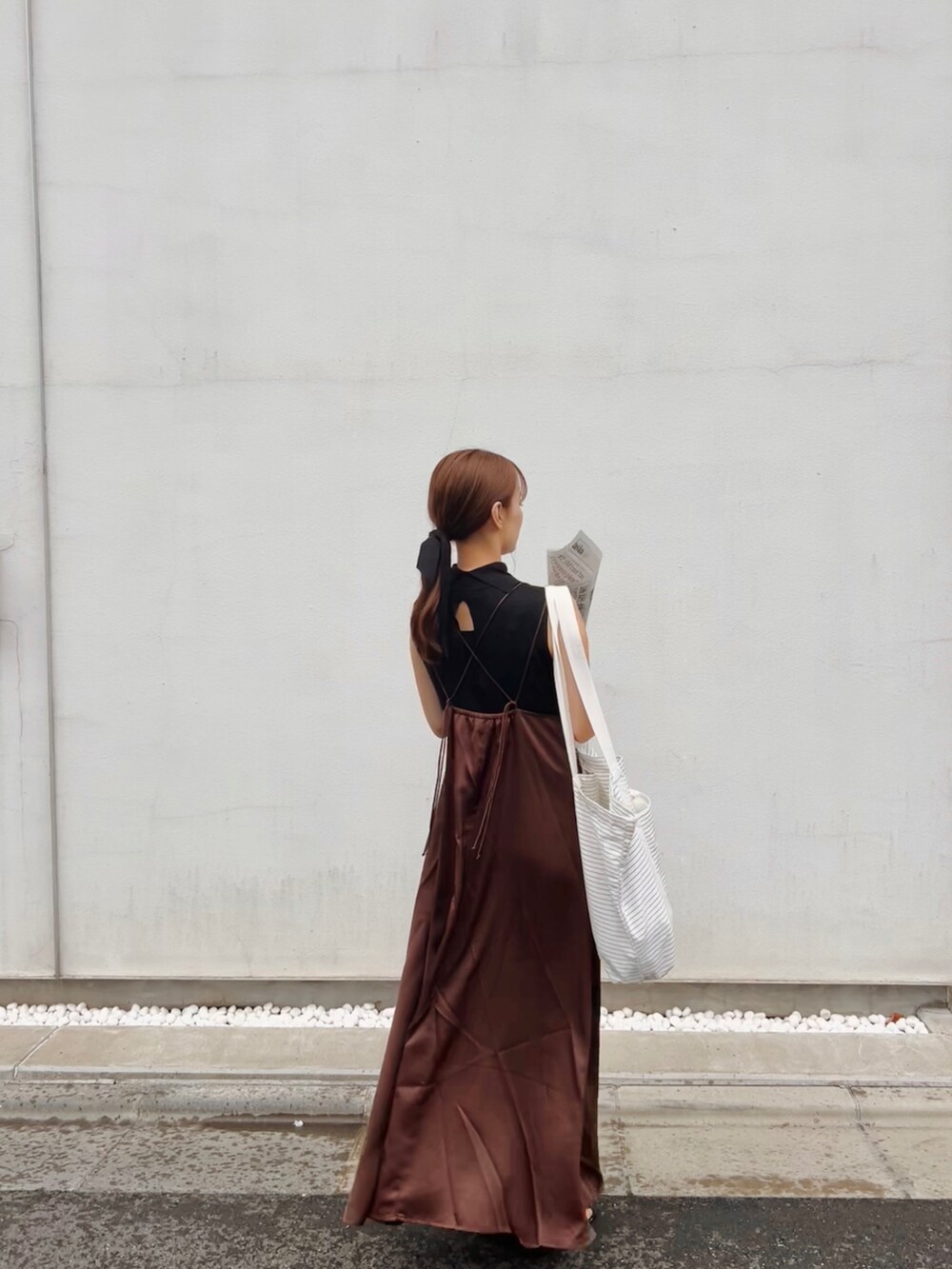 ブラウン系のワンピース、ブラック系のサンダル、ホワイト系のエコバッグ/サブバッグを着用したレディースの夏コーディネートの2枚目の写真