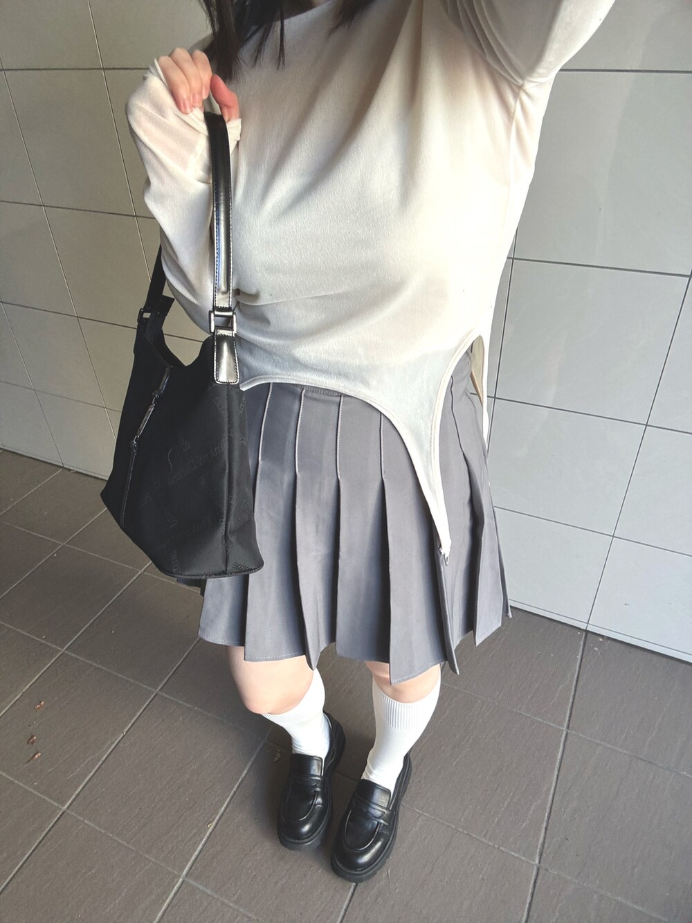 ホワイト系のTシャツ/カットソー、ブラック系のハンドバッグを着用したレディースの冬コーディネートの2枚目の写真