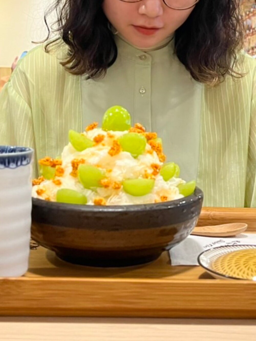 グリーン系のシャツ/ブラウス、ホワイト系のデニムパンツを着用したレディースの春コーディネートの2枚目の写真