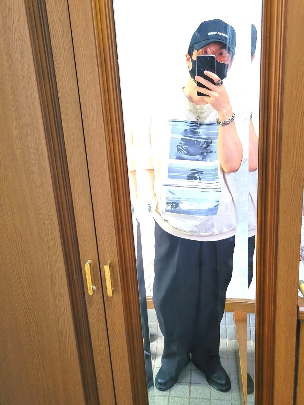 ベージュ系のTシャツ/カットソー、ブラック系のスラックス、ブラック系のドレスシューズを着用したメンズの夏コーディネートの2枚目の写真