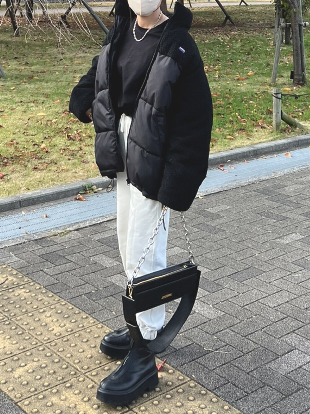ブラック系のその他アウター、ホワイト系のスウェットパンツ、ブラック系のショルダーバッグを着用したレディースの冬コーディネートの3枚目の写真