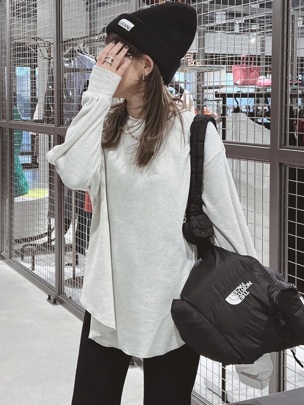 ホワイト系のTシャツ/カットソー、ブラック系のブーツ、ブラック系のニットキャップ/ビーニーを着用したレディースの冬コーディネートの2枚目の写真