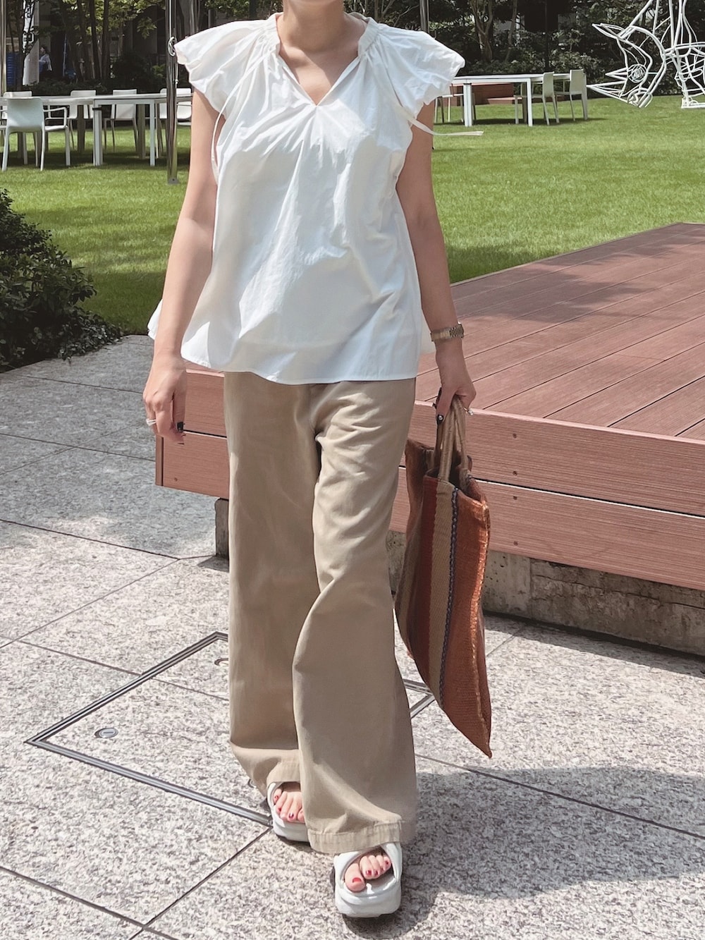 ホワイト系のシャツ/ブラウス、ベージュ系のその他パンツ、ブラウン系のバッグを着用したレディースの夏コーディネートの4枚目の写真