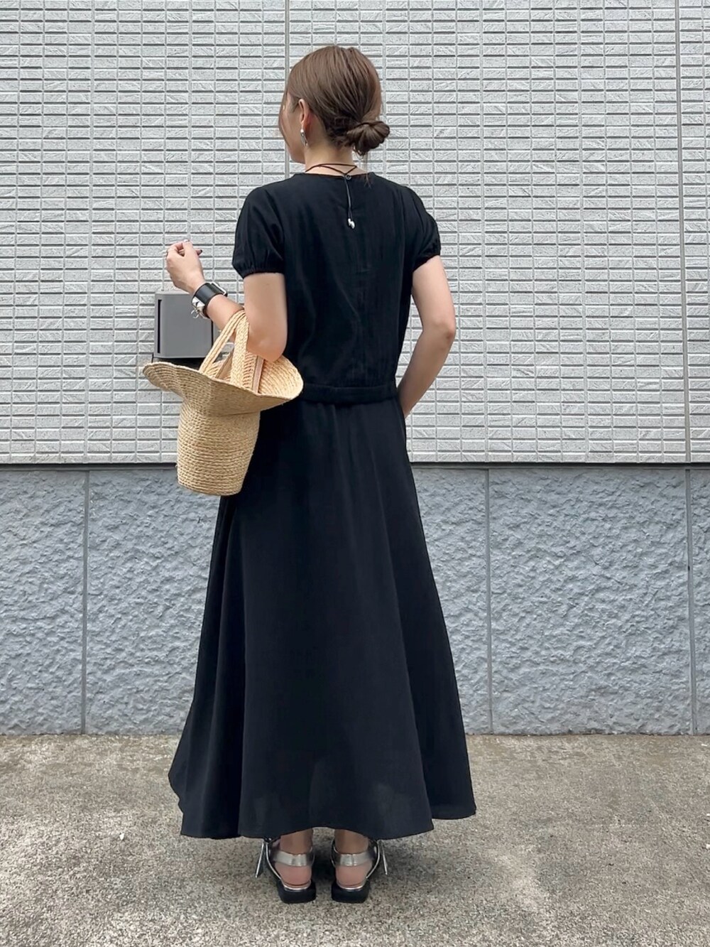 ブラック系のセットアップ、ベージュ系のかごバッグ、シルバー系のパンプスを着用したレディースの春コーディネートの2枚目の写真