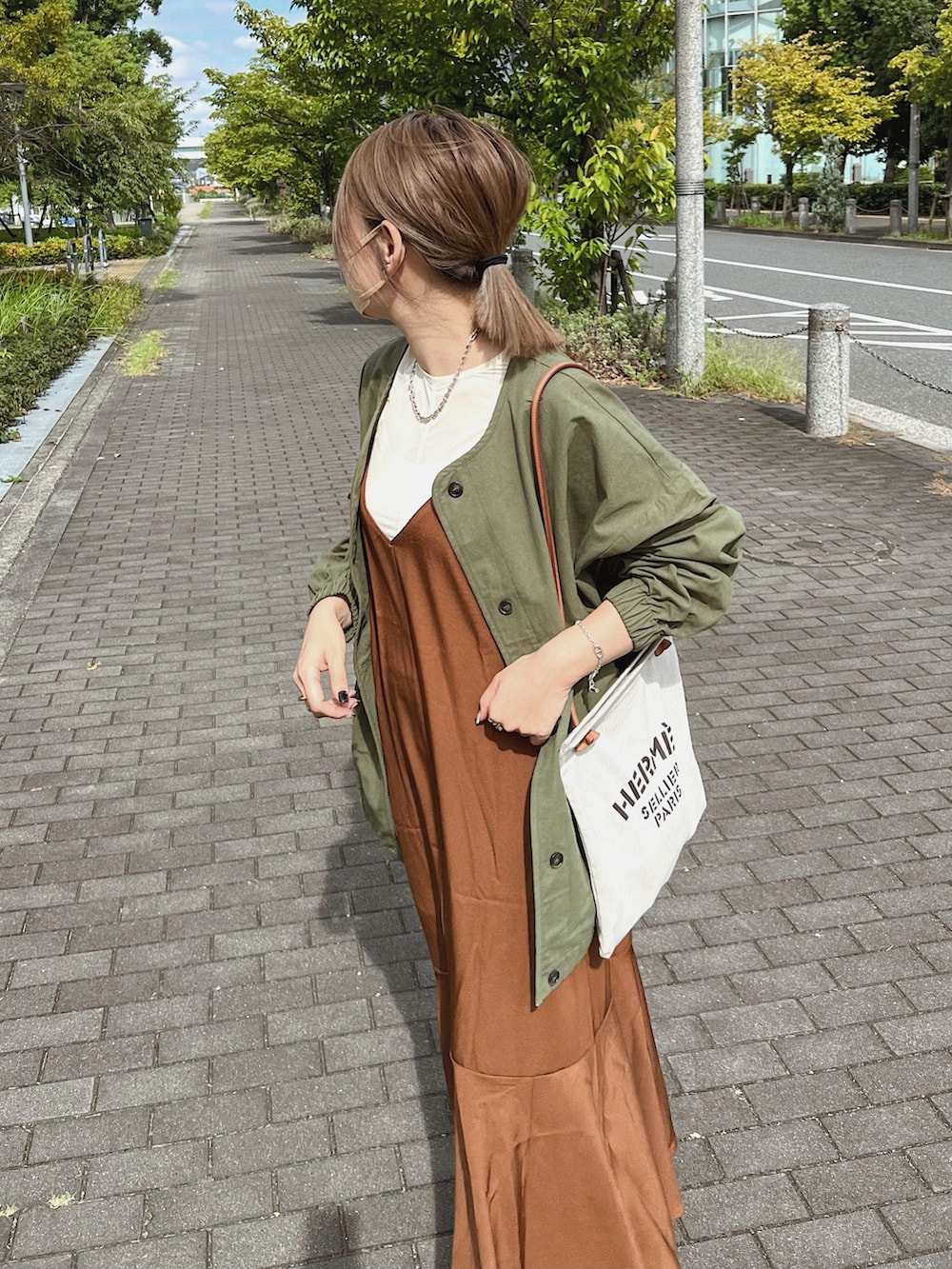 グリーン系のノーカラージャケット、ブラウン系のワンピース、ベージュ系のトートバッグを着用したレディースの秋コーディネートの3枚目の写真