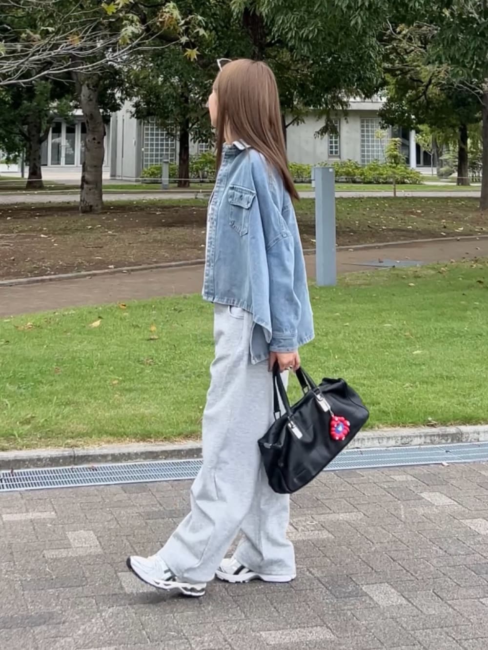 ブルー系のシャツ/ブラウス、グレー系のスウェットパンツ、ホワイト系のスニーカーを着用したレディースの秋コーディネートの3枚目の写真