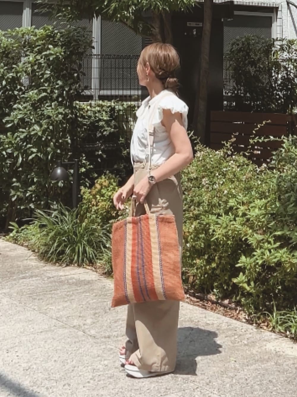 ホワイト系のシャツ/ブラウス、ベージュ系のその他パンツ、ブラウン系のバッグを着用したレディースの夏コーディネートの2枚目の写真