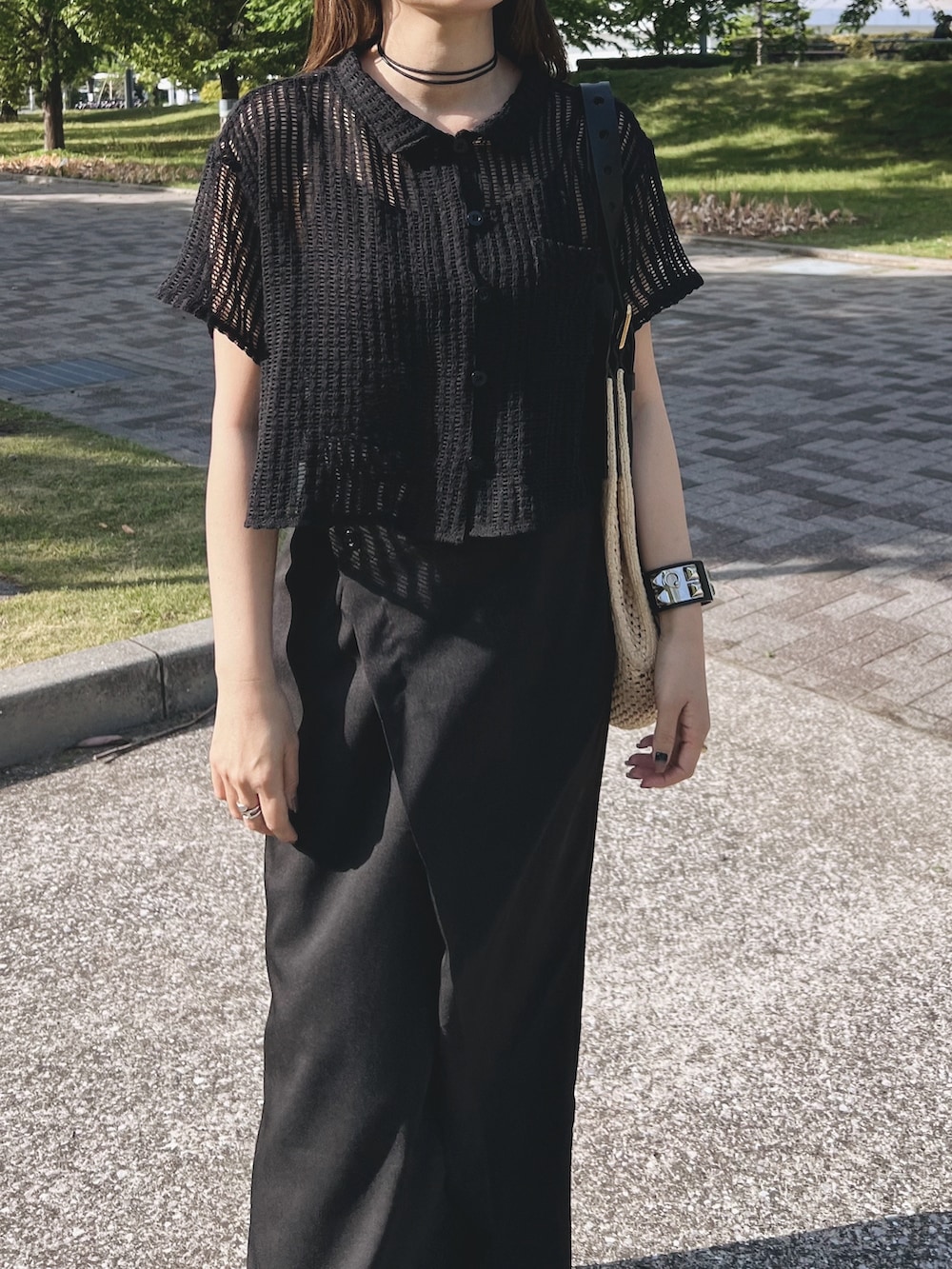 ブラック系のシャツ/ブラウス、ブラック系のスカート、ホワイト系のスニーカーを着用したレディースの春コーディネートの2枚目の写真