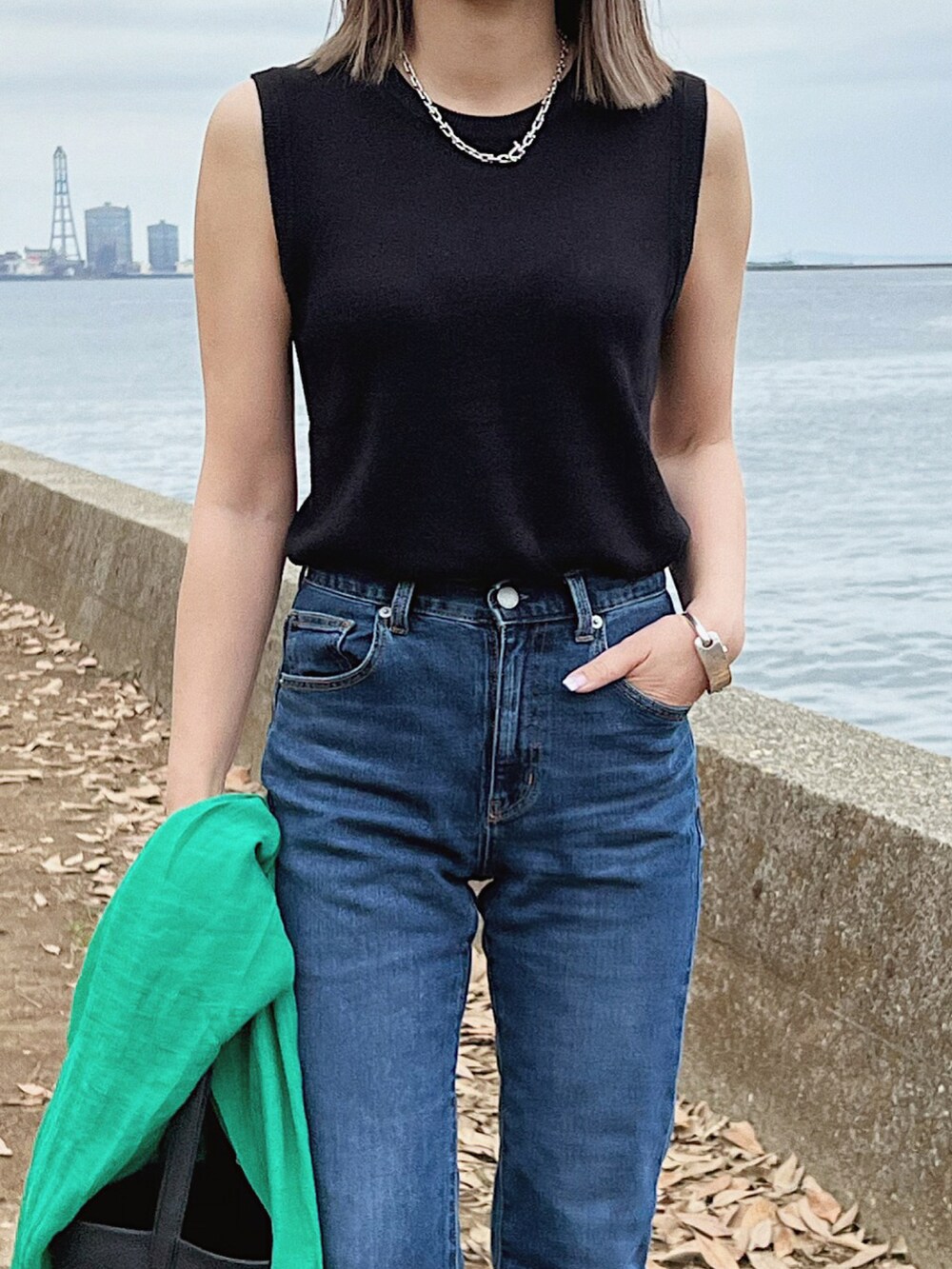 グリーン系のカーディガン/ボレロ、ブラック系のニット/セーター、ブルー系のデニムパンツを着用したレディースの春コーディネートの3枚目の写真