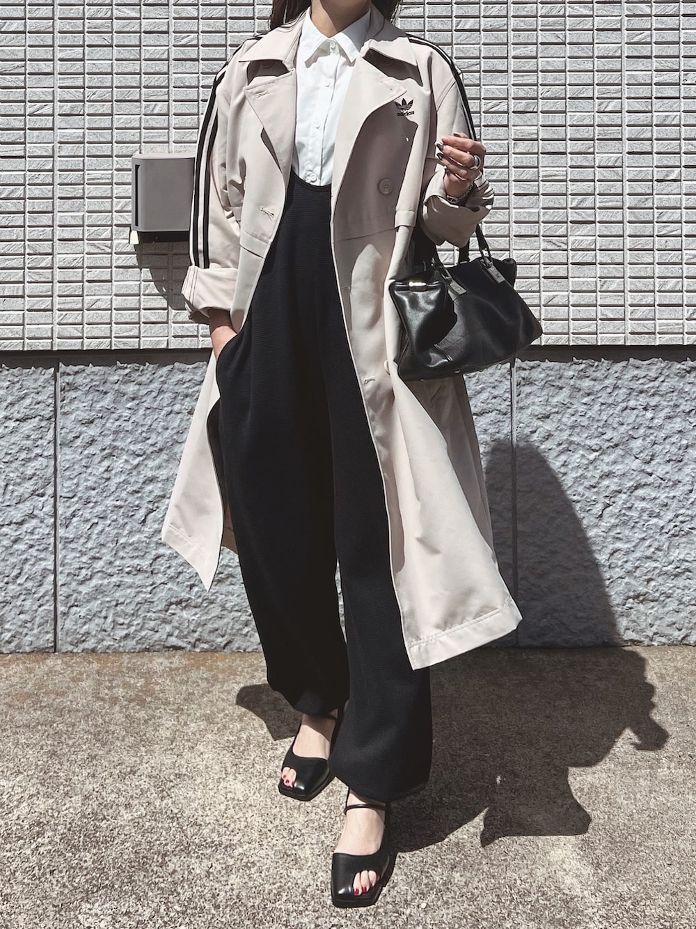 ブラック系のサロペット/オーバーオール、ホワイト系のシャツ/ブラウス、ブラック系のバッグを着用したレディースの春コーディネートの2枚目の写真
