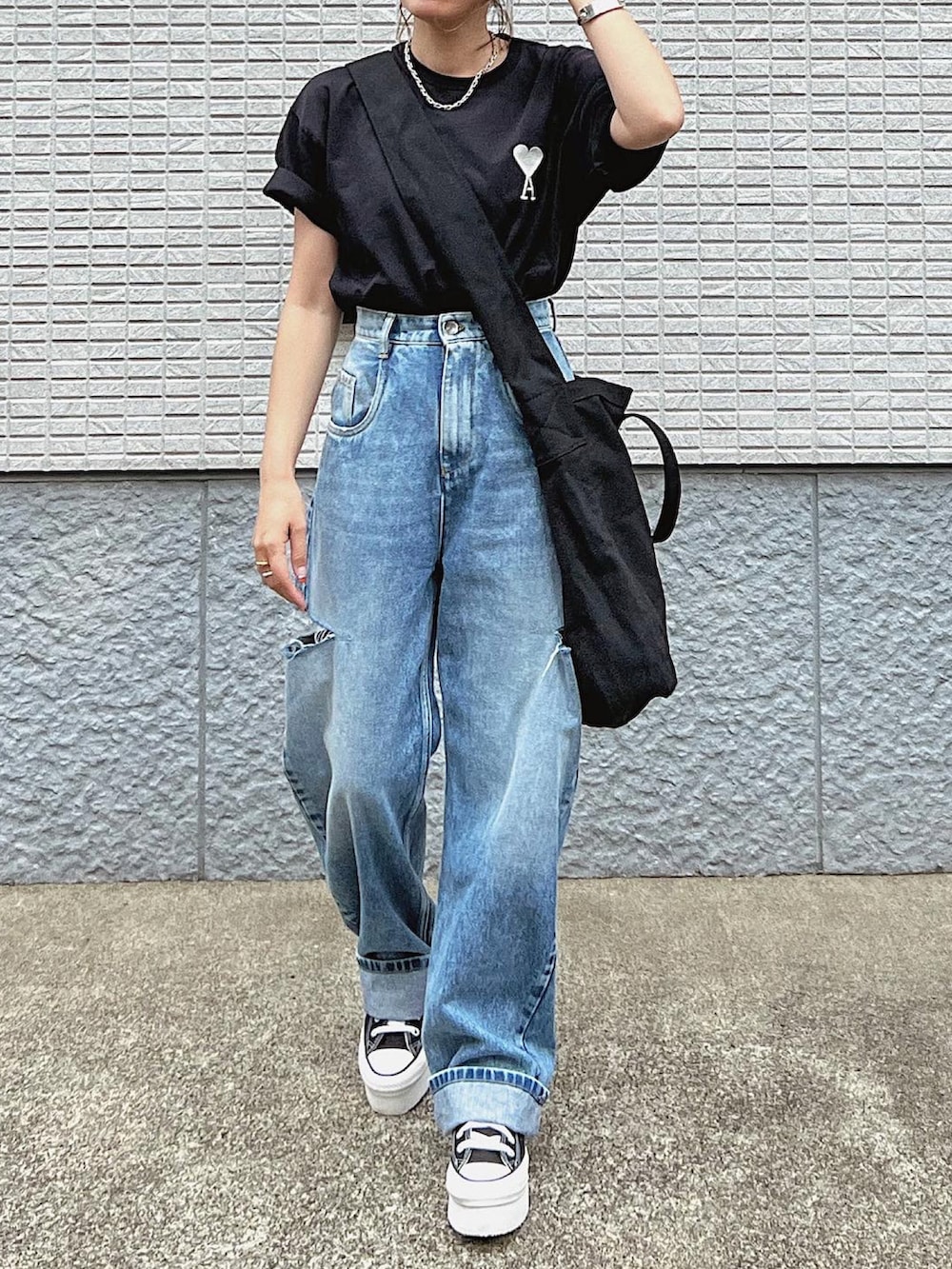 ブラック系のショルダーバッグ、ブラック系のTシャツ/カットソー、ブルー系のデニムパンツを着用したレディースの夏コーディネートの3枚目の写真