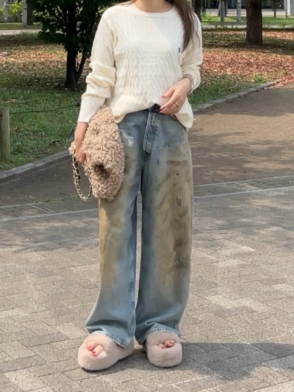 ホワイト系のニット/セーター、ブルー系のデニムパンツ、ベージュ系のサンダルを着用したレディースの秋コーディネートの2枚目の写真