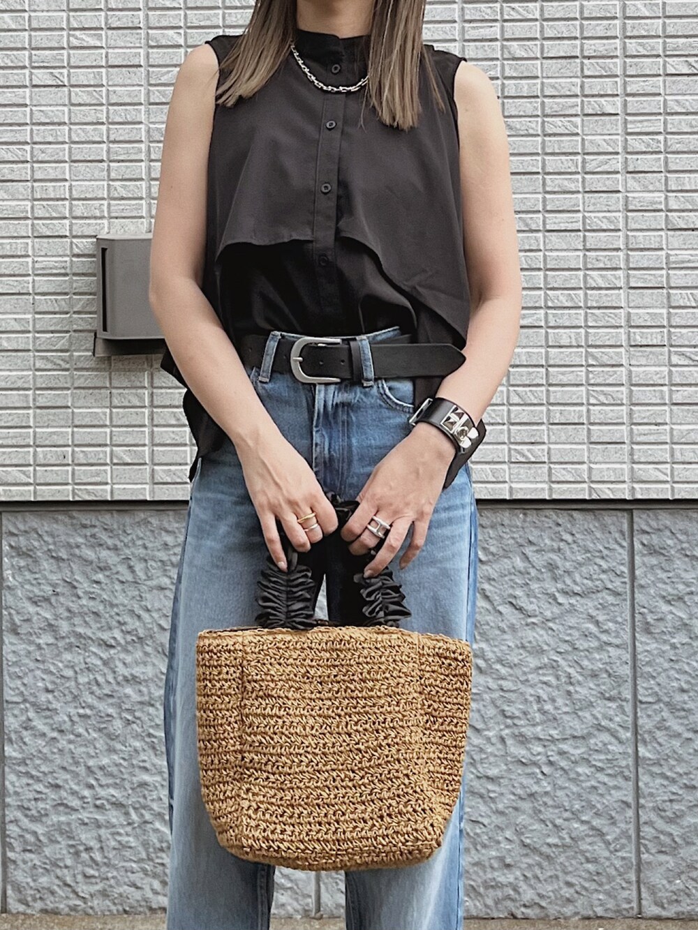 ブラック系のワンピース、ベージュ系のバッグ、ブラック系のサンダルを着用したレディースの夏コーディネートの4枚目の写真