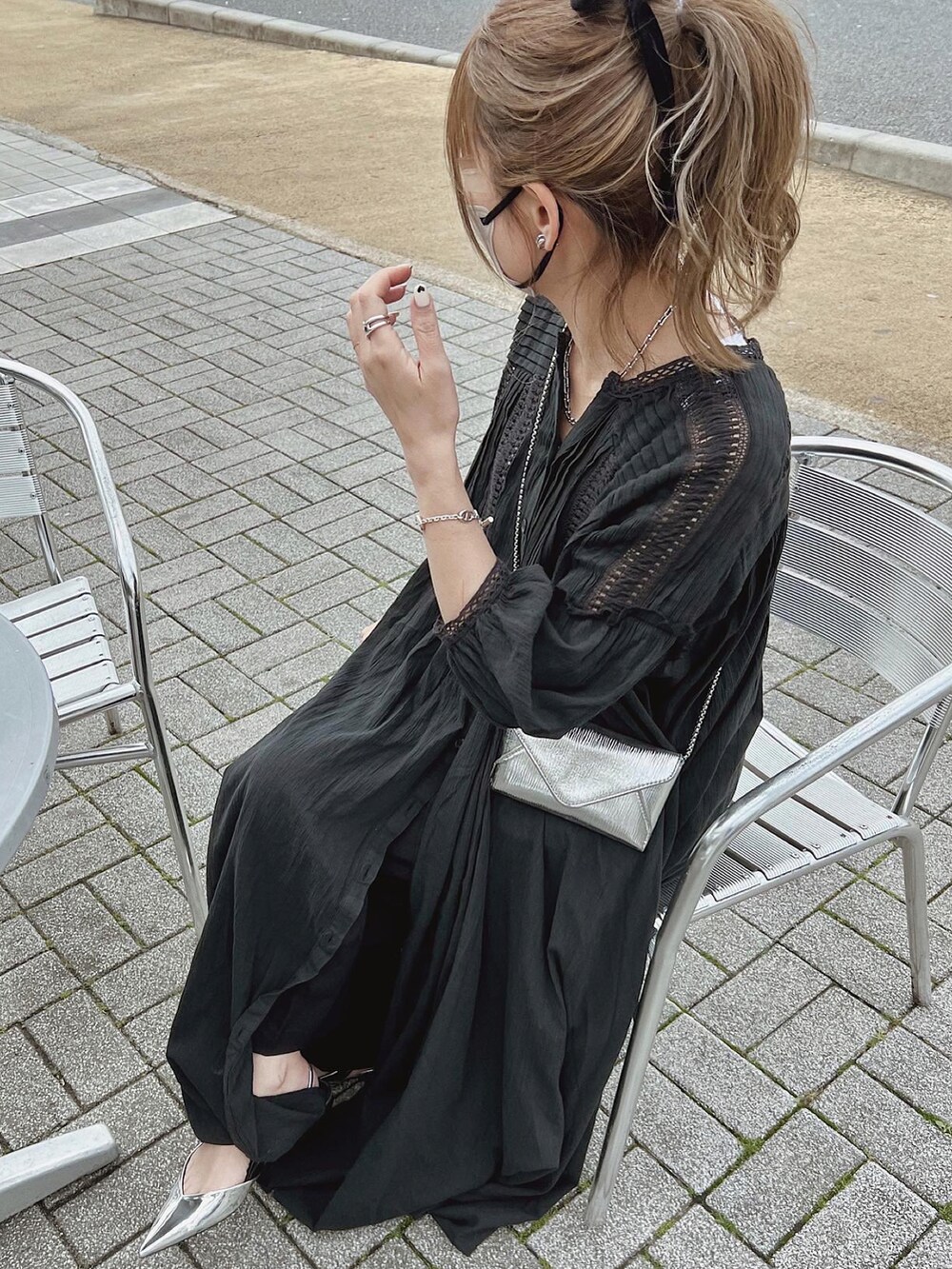 シルバー系のショルダーバッグ、シルバー系のサンダル、ブラック系のシャツワンピースを着用したレディースの春コーディネートの3枚目の写真