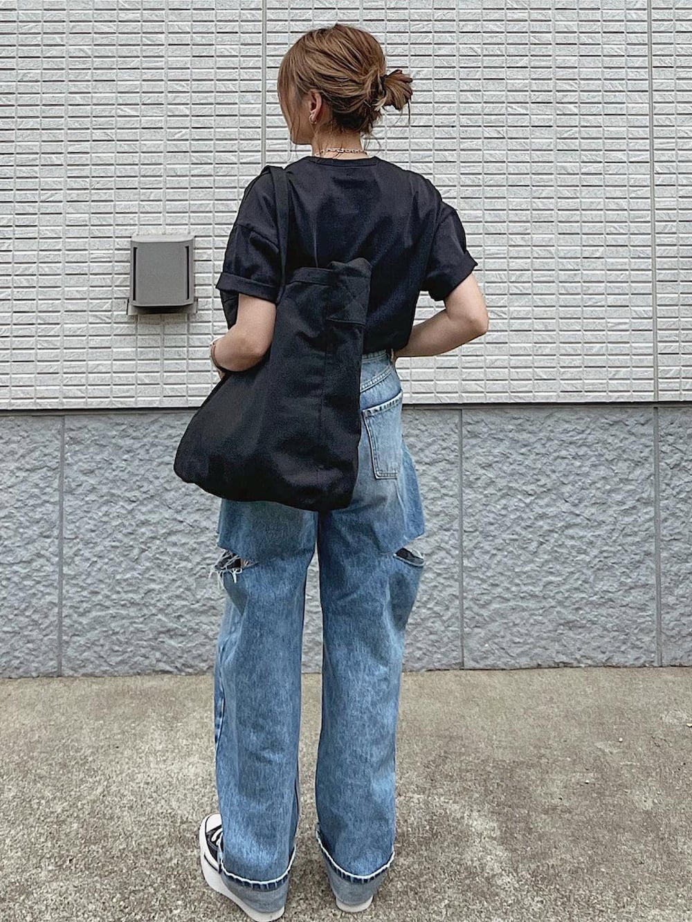 ブラック系のショルダーバッグ、ブラック系のTシャツ/カットソー、ブルー系のデニムパンツを着用したレディースの夏コーディネートの2枚目の写真