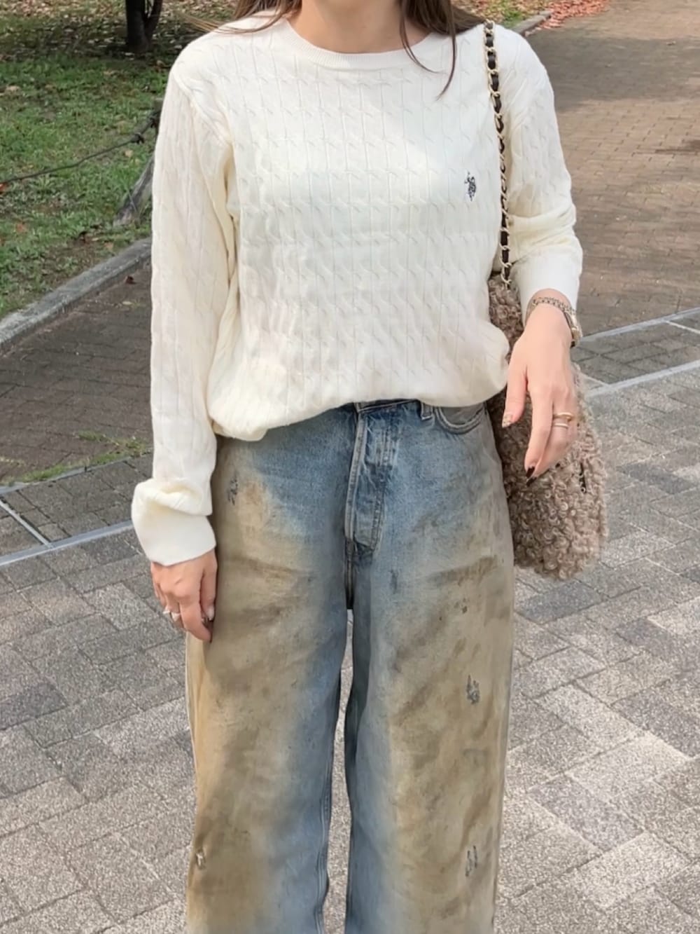 ホワイト系のニット/セーター、ブルー系のデニムパンツ、ベージュ系のサンダルを着用したレディースの秋コーディネートの3枚目の写真
