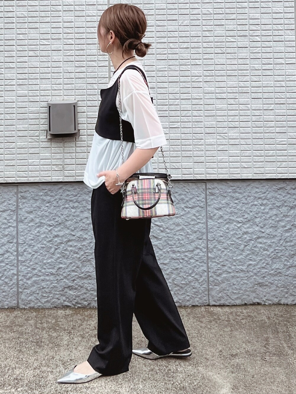 ホワイト系のTシャツ/カットソー、ブラック系のベスト、ブラック系のパンツを着用したレディースの夏コーディネートの2枚目の写真