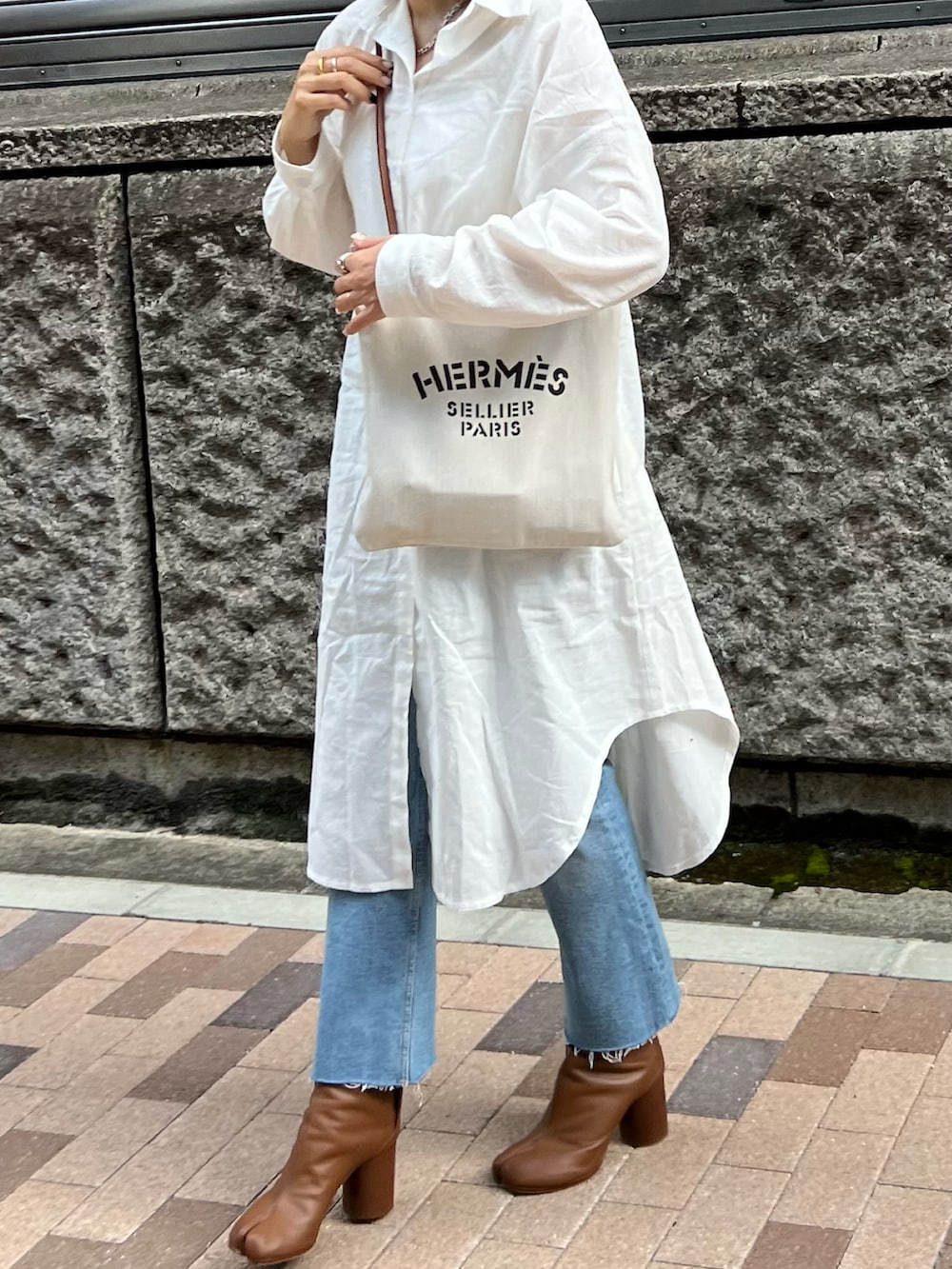 ホワイト系のシャツワンピース、ホワイト系のショルダーバッグ、ブラウン系のブーツを着用したレディースの秋コーディネートの2枚目の写真