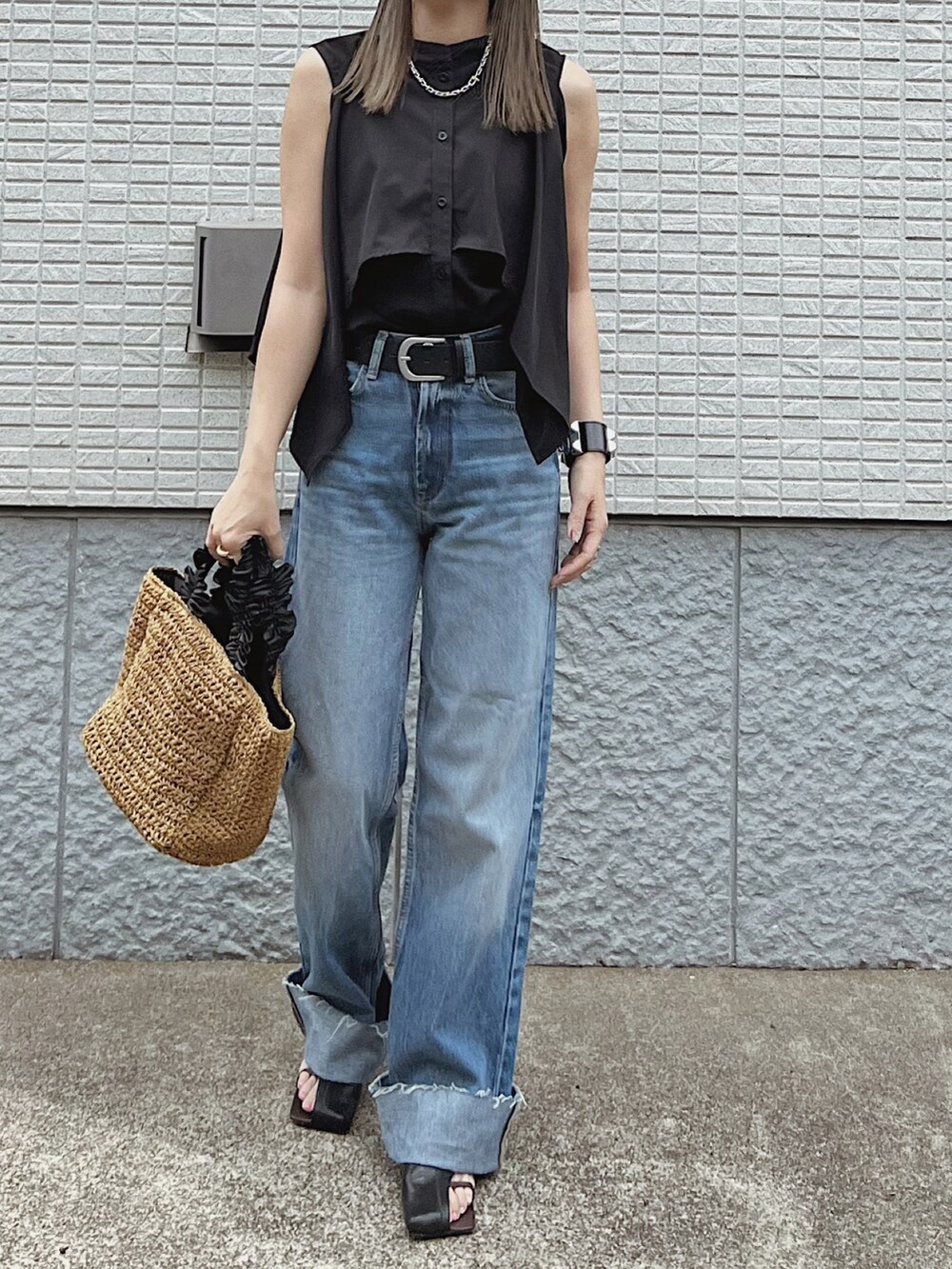 ブラック系のワンピース、ベージュ系のバッグ、ブラック系のサンダルを着用したレディースの夏コーディネートの3枚目の写真