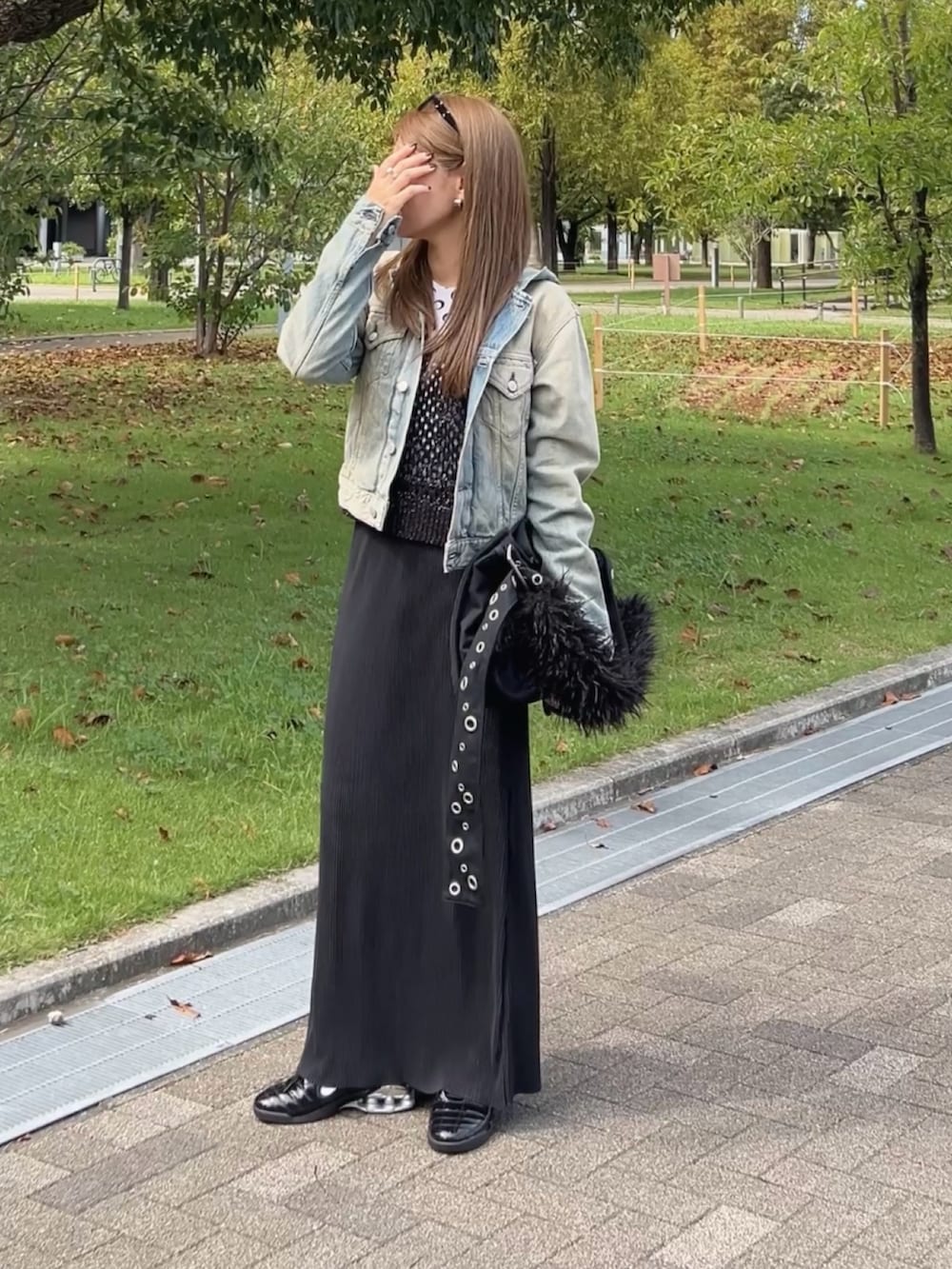 ブルー系のデニムジャケット、ブラック系のショルダーバッグ、ホワイト系のトップスを着用したレディースの秋コーディネートの3枚目の写真