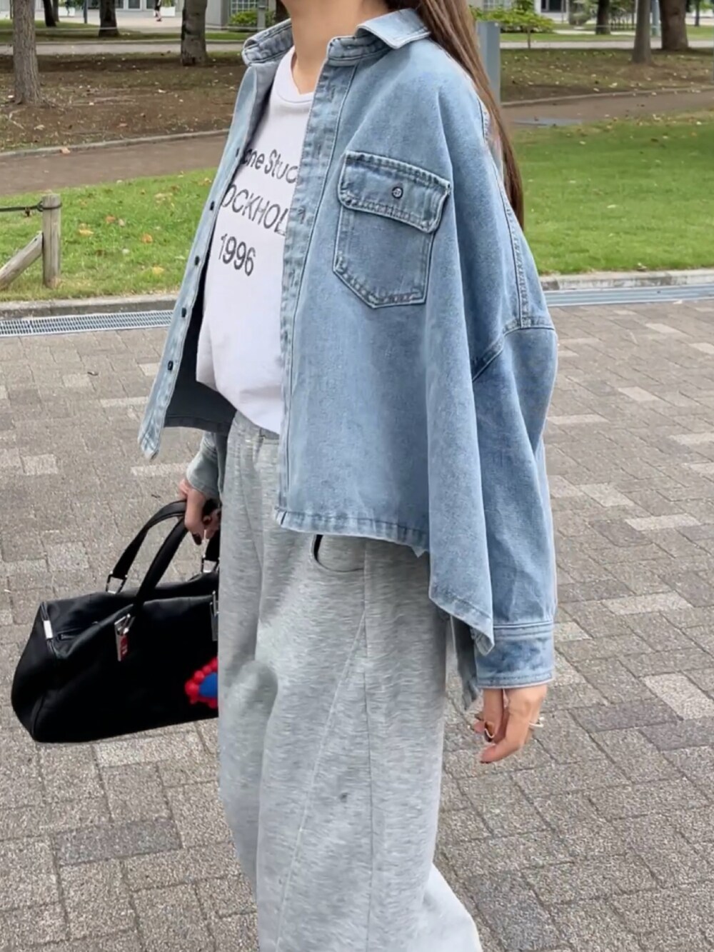 ブルー系のシャツ/ブラウス、グレー系のスウェットパンツ、ホワイト系のスニーカーを着用したレディースの秋コーディネートの2枚目の写真