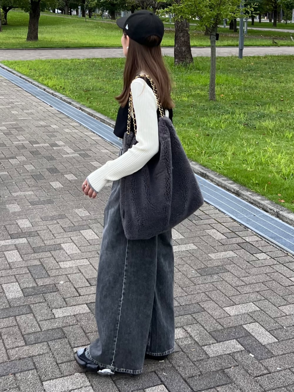 ホワイト系のニット/セーター、ブラック系のデニムパンツ、ブラック系のベストを着用したレディースの秋コーディネートの3枚目の写真