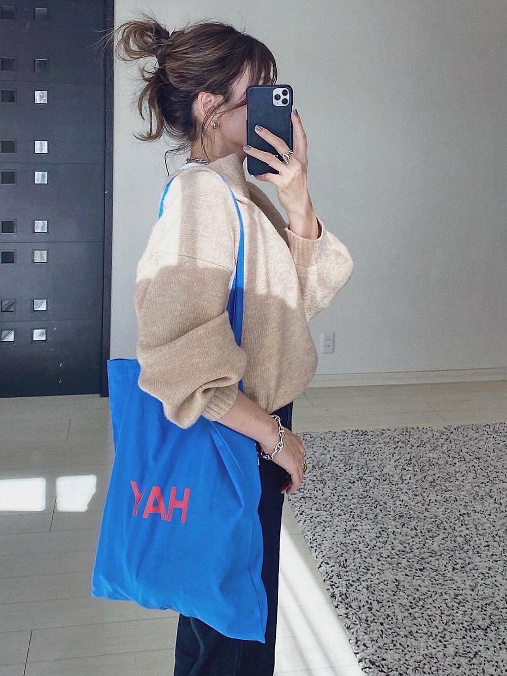 ベージュ系のニット/セーター、ブルー系のデニムパンツ、ブルー系のバッグを着用したレディースの秋コーディネートの3枚目の写真