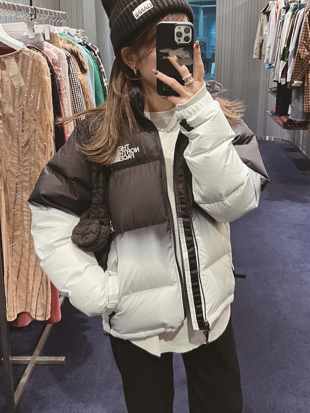 ホワイト系のTシャツ/カットソー、ブラック系のブーツ、ブラック系のニットキャップ/ビーニーを着用したレディースの冬コーディネートの5枚目の写真