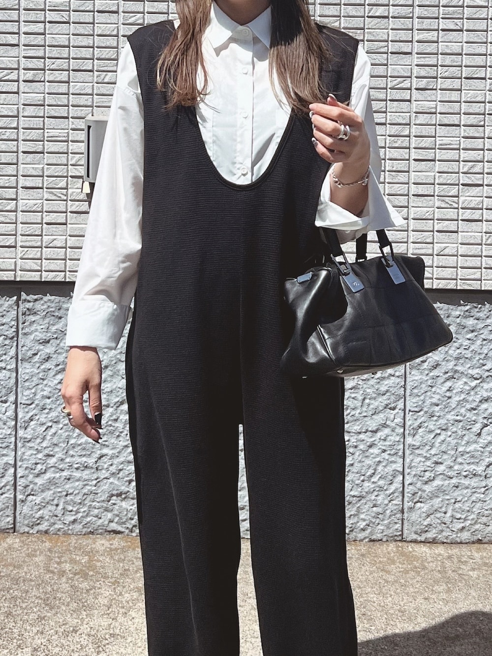 ブラック系のサロペット/オーバーオール、ホワイト系のシャツ/ブラウス、ブラック系のバッグを着用したレディースの春コーディネートの4枚目の写真