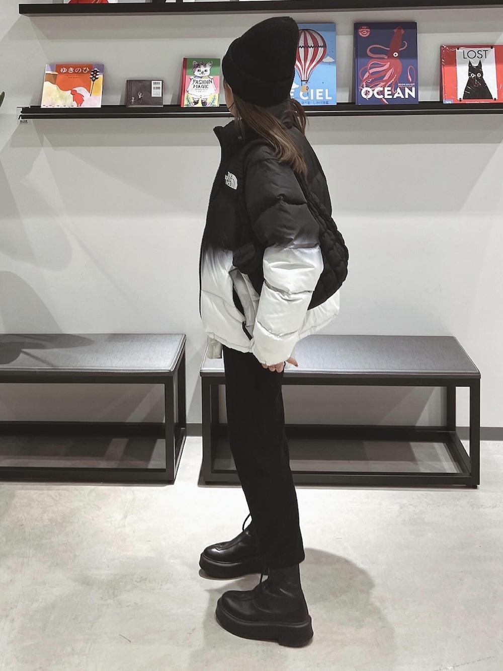 ホワイト系のTシャツ/カットソー、ブラック系のブーツ、ブラック系のニットキャップ/ビーニーを着用したレディースの冬コーディネートの4枚目の写真