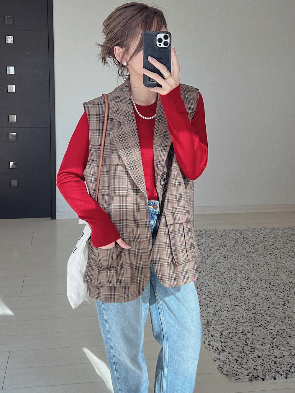 ブラウン系のテーラードジャケット、ブルー系のデニムパンツ、レッド系のニット/セーターを着用したレディースの秋コーディネートの3枚目の写真