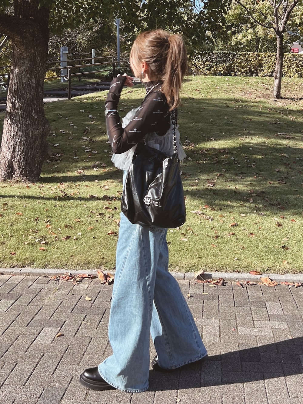 グレー系のキャミソール、ブラック系のTシャツ/カットソー、ブルー系のデニムパンツを着用したレディースの秋コーディネートの2枚目の写真