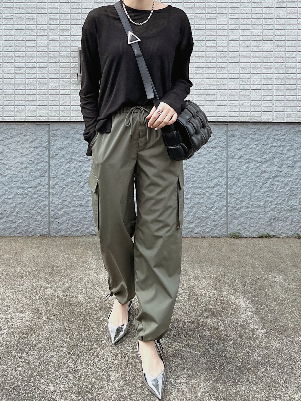 ホワイト系のトレンチコート、グリーン系のカーゴパンツ、ブラック系のTシャツ/カットソーを着用したレディースの冬コーディネートの4枚目の写真