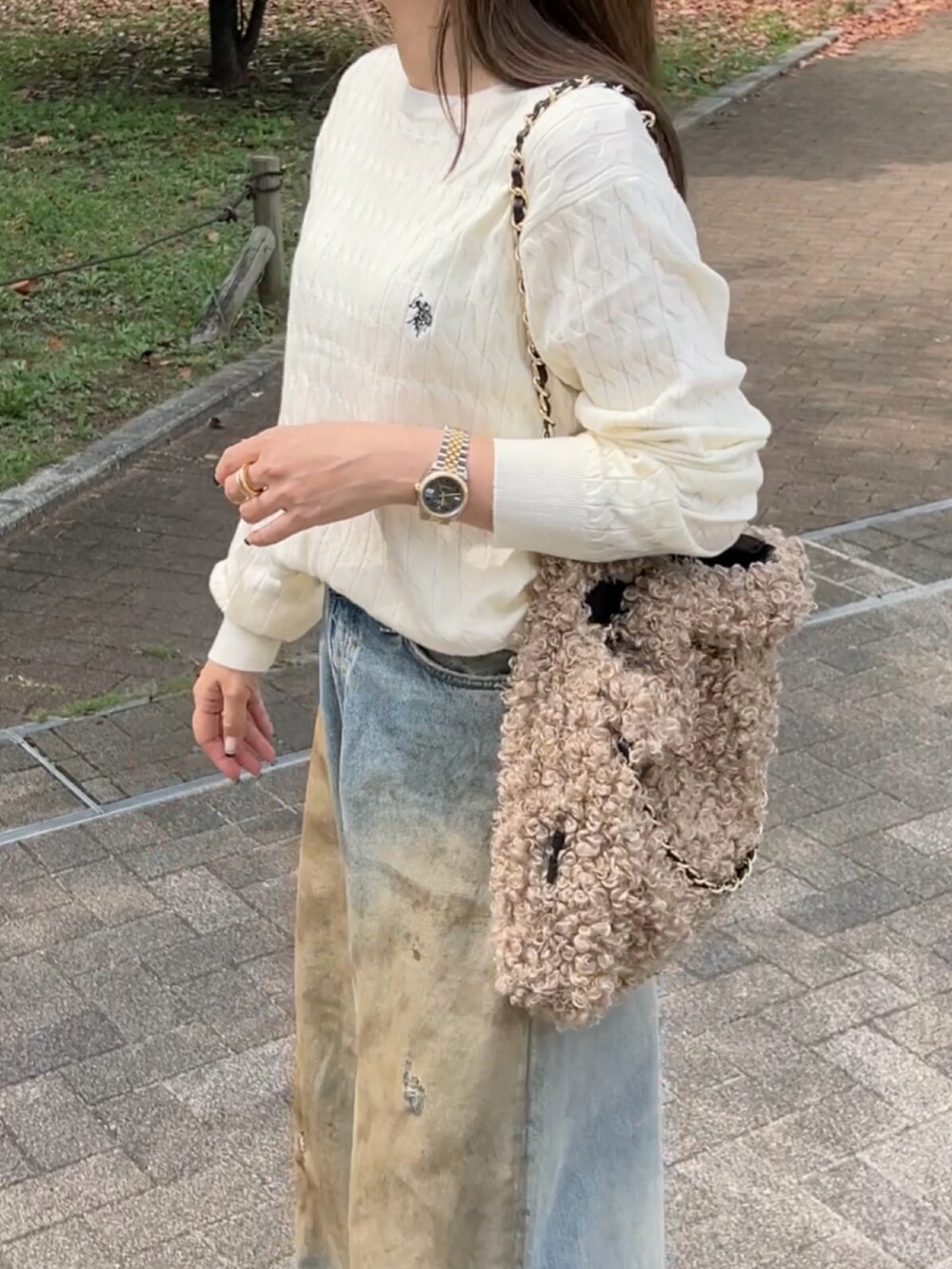 ホワイト系のニット/セーター、ブルー系のデニムパンツ、ベージュ系のサンダルを着用したレディースの秋コーディネートの4枚目の写真